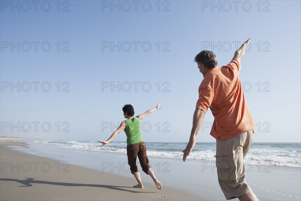 Caucasian couple playing on beach