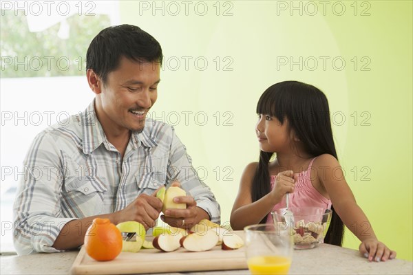 Asian father and daughter having breakfast together
