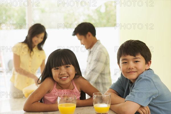 Children drinking orange juice at breakfast