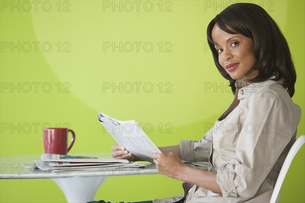 Woman reading newspaper in cafe