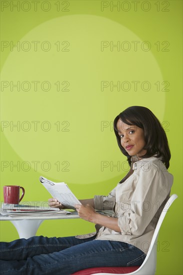 Woman reading newspaper in cafe