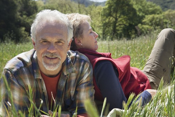 Senior Caucasian couple relaxing in tall grass