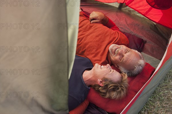 Senior Caucasian couple relaxing in tent