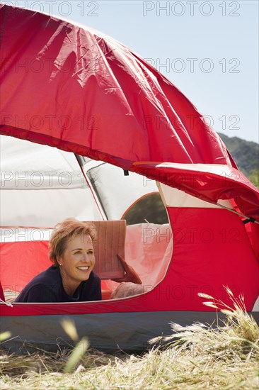 Senior Caucasian woman relaxing in tent