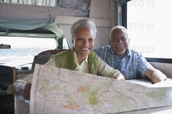 Mixed race Senior couple reading map in RV