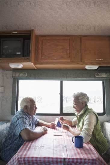 Mixed race Senior couple having coffee in RV