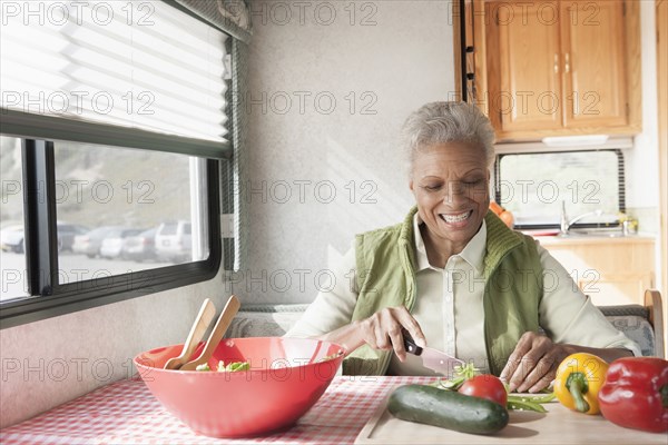 Mixed race Senior woman cooking in RV