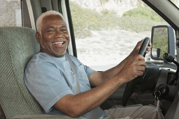 Mixed race Senior man driving RV