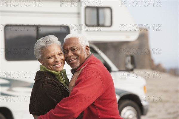 Mixed race Senior couple hugging by RV