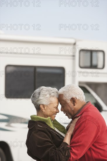 Mixed race Senior couple hugging by RV