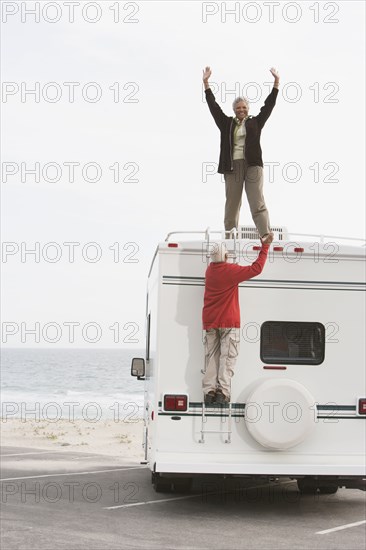 Mixed race Senior couple cheering on RV