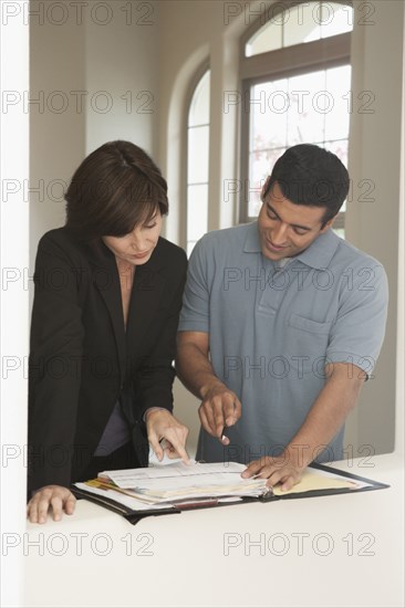 Realtor and client signing papers in new home