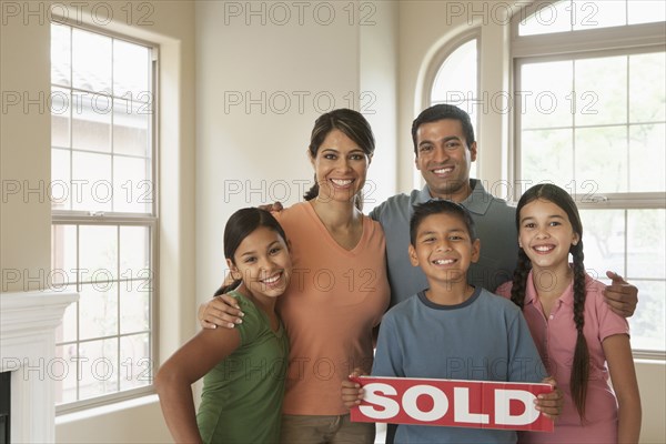 Hispanic family smiling in new home