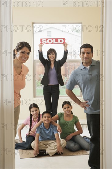 Realtor and family smiling in new home