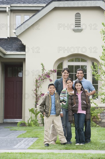 Hispanic family smiling outside home