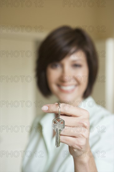 Mixed race woman holding key to new home