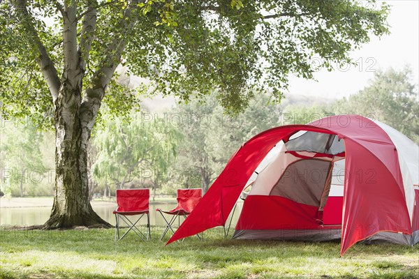 Lawn chairs and tent at campsite