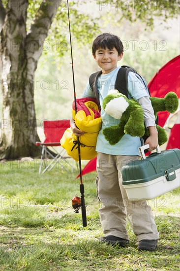 Asian boy carrying camping gear