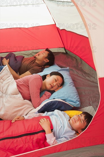 Asian family sleeping in tent