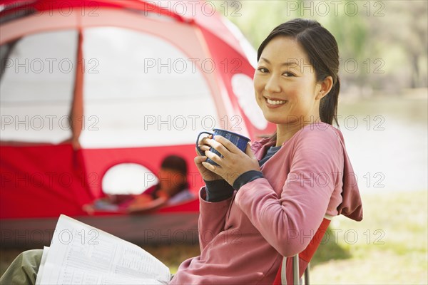 Woman drinking coffee at campsite