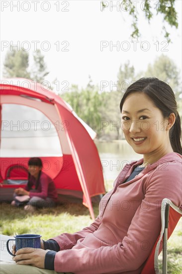 Woman drinking coffee at campsite
