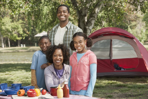 Family smiling together at campsite