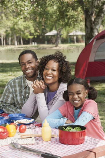 Family smiling together at campsite