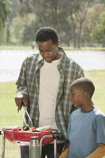 Father and son cooking at picnic table