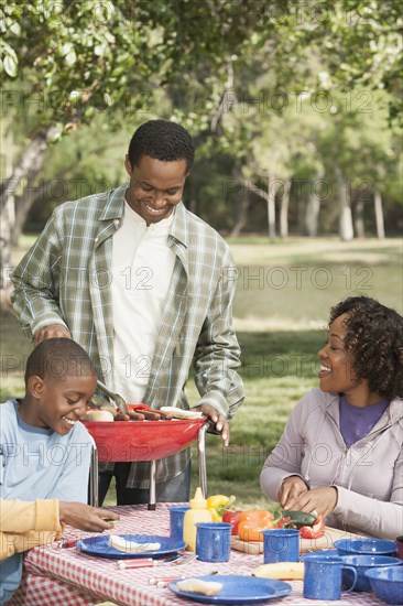 Family cooking together at picnic