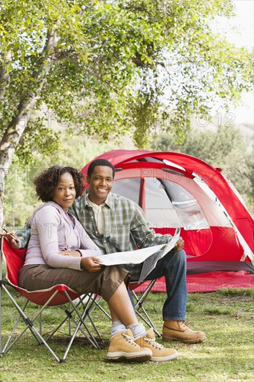 Couple reading newspaper together at campsite