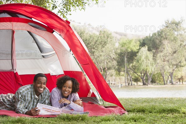 Couple reading newspaper together in tent