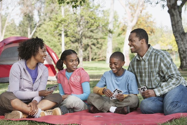 Family playing cards at campsite