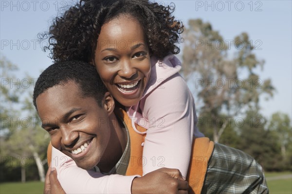 Man carrying girlfriend in park