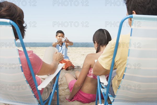 Family taking pictures together on beach