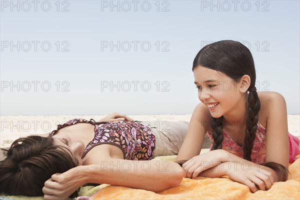 Mother and daughter relaxing on beach