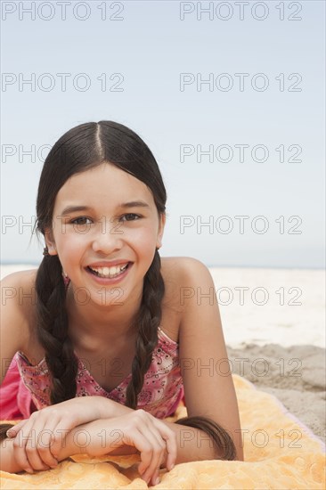 Hispanic girl laying on beach