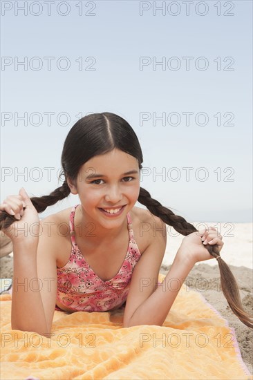 Hispanic girl laying on beach