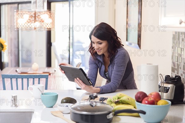 Caucasian woman using digital tablet in domestic kitchen