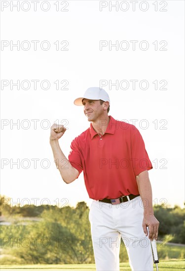 Hispanic golfer celebrating on golf course