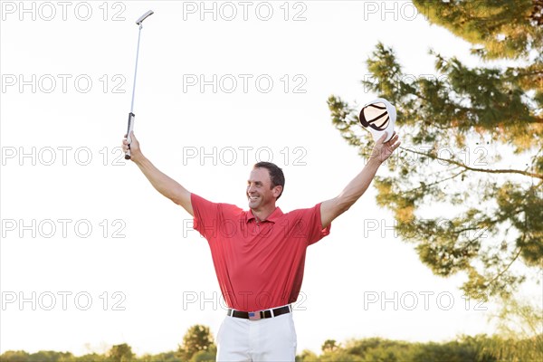 Hispanic golfer waving on golf course