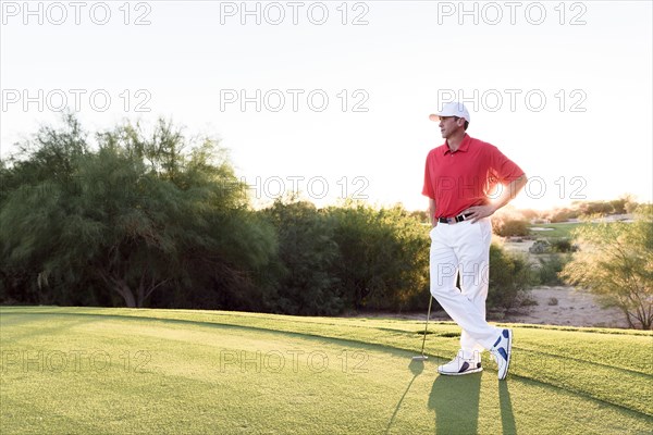 Hispanic golfer waiting on golf course