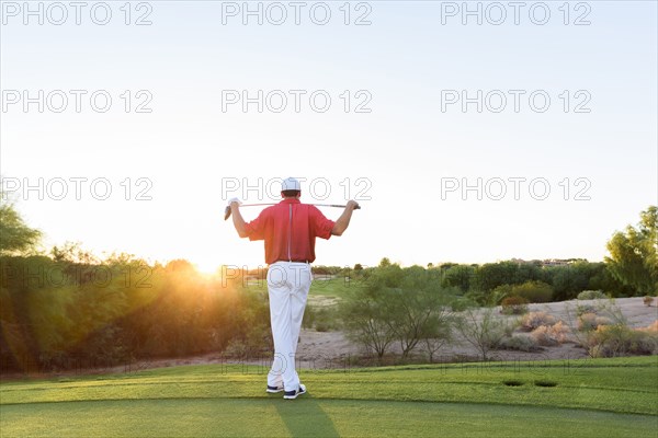 Hispanic golfer waiting on golf course