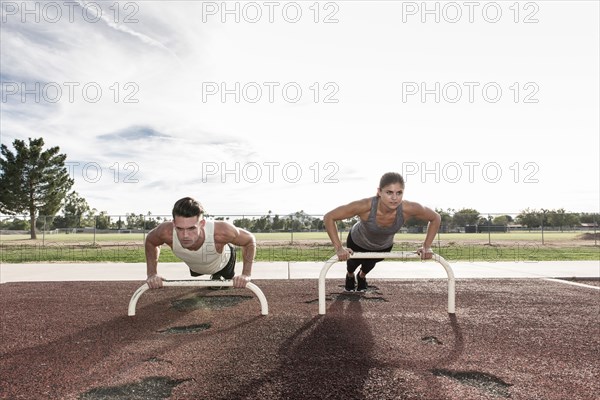 Couple doing push-ups outdoors