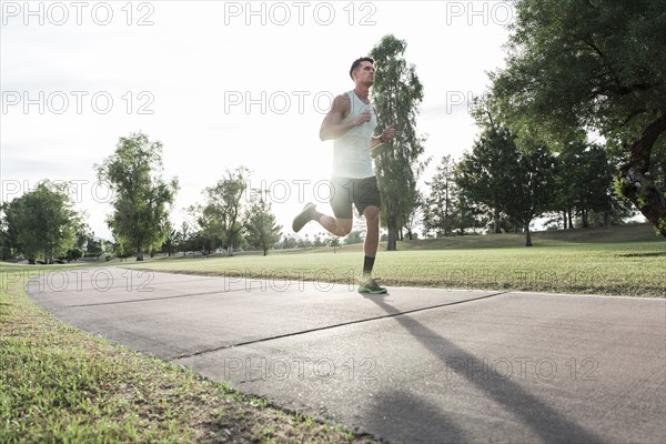 Caucasian man running on path in park