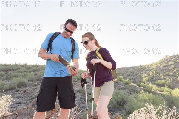 Couple using digital tablet while hiking