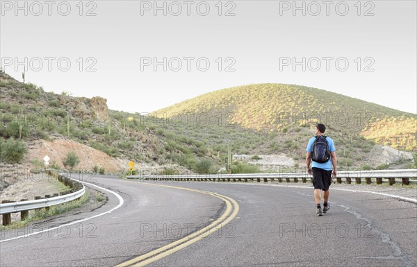 Hispanic man hiking on winding street