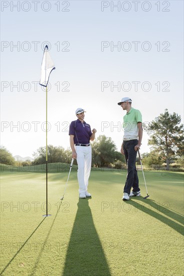 Friends talking on golf course