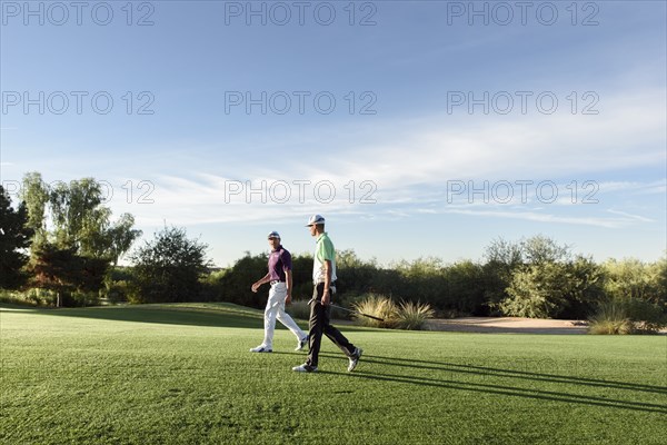 Friends walking on golf course