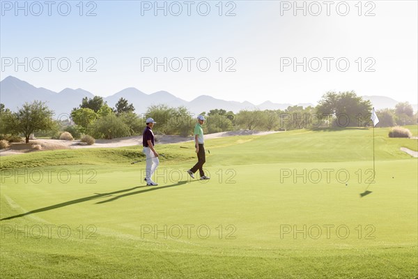 Friends walking on golf course