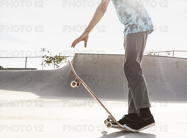 Hispanic man stepping on tail of skateboard